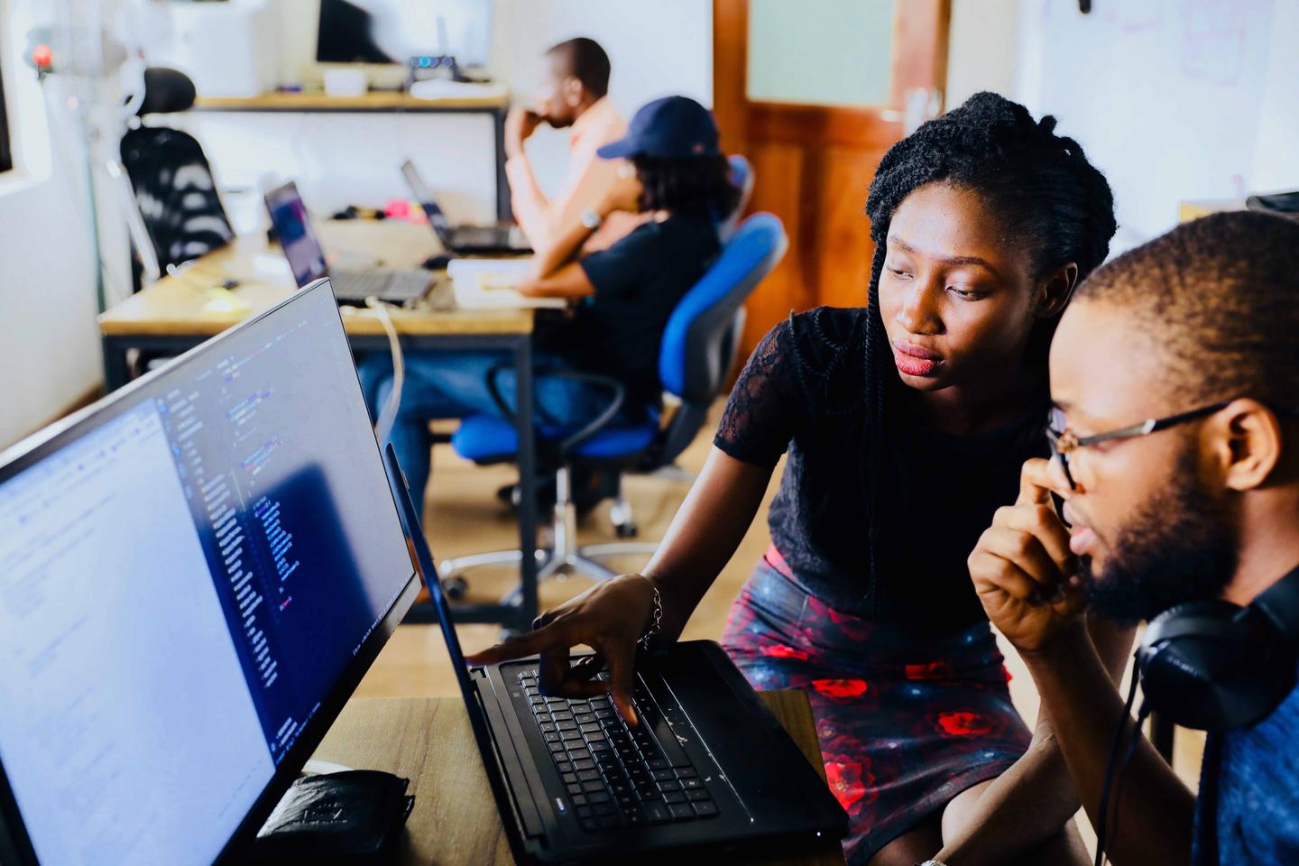 Two people working on a website on a computer.